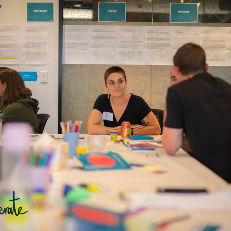 a person sits listening to a conversation on a training course